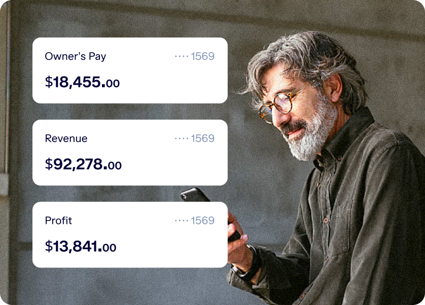 A person with gray hair and beard, wearing glasses and a button-up shirt, looks at a smartphone. Beside the person are three financial statistics: Owner’s Pay ($18,455.00), Revenue ($92,278.00), and Profit ($13,841.00).
