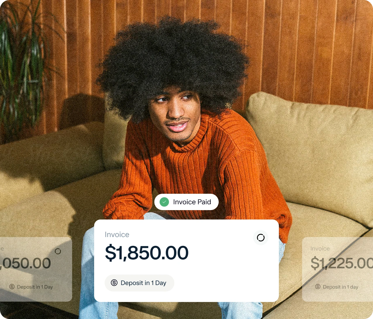 A person with curly hair in an orange sweater sits on a beige couch. Overlaid graphics show an invoice paid for $1,850.00 with a note: "Deposit in 1 day.