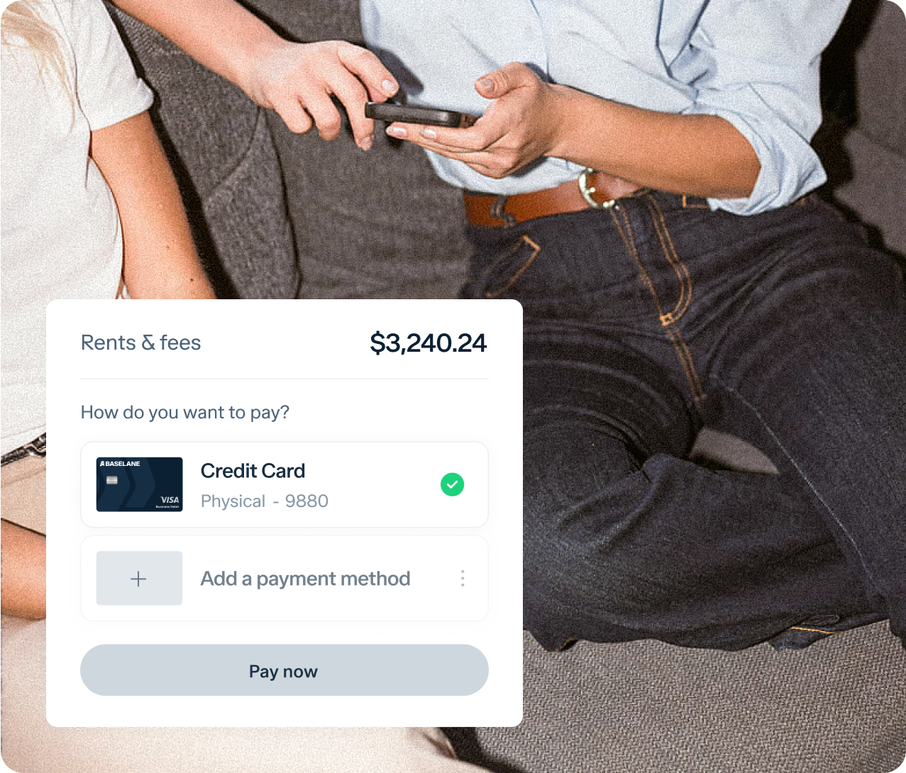 Two people are sitting on a couch, with an online payment interface displayed in the foreground. The interface shows a transaction for "Rents & fees" totaling $3,240.24 being paid by a credit card ending in 9880. One person is holding a phone.