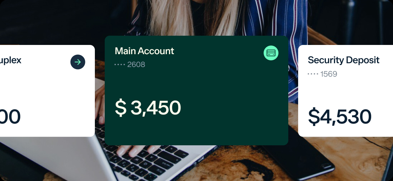 A person typing on a laptop is partially visible in the background. Overlaid on the image are three financial account summaries: "Main Account" with a balance of $3,450, "Security Deposit" with a balance of $4,530, and part of another account on the left.