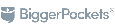 Logo of BiggerPockets featuring a stylized shield with a house inside, followed by the text "BiggerPockets" in a sleek, blue font.