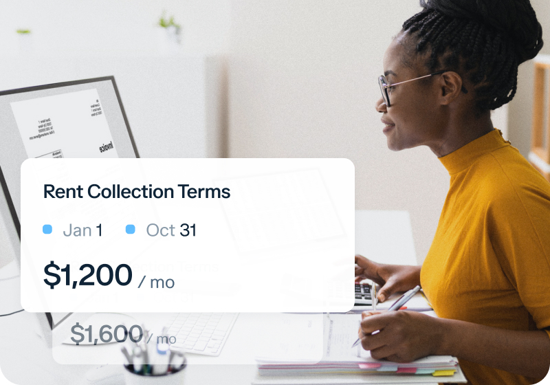 A person in a yellow top works at a computer. A pop-up on the screen shows "Rent Collection Terms," with dates Jan 1 to Oct 31, and rent amount $1,200/mo, reduced from $1,600/mo.