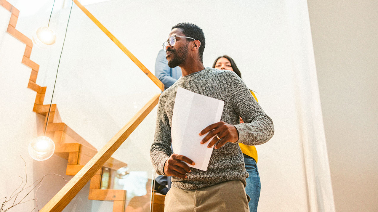 A young man walking through a house with the landlord